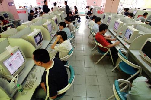 Internet Cafe - This is people that are using computers in a internet cafe.