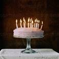 Birthday cake with candles -  A white birthday cake with many lit candles.