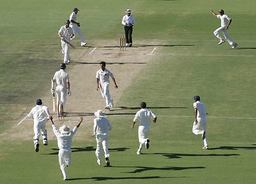 Victory - Indians gather to celebrate the final wicket of Tait.