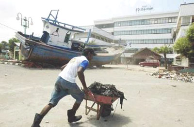 Images of Aceh 1 - A wooden fishing boat lies in front of Hotel Medan, the first tsunami hit hotel that reopened in Banda Aceh with 20 of its 80 rooms ready.