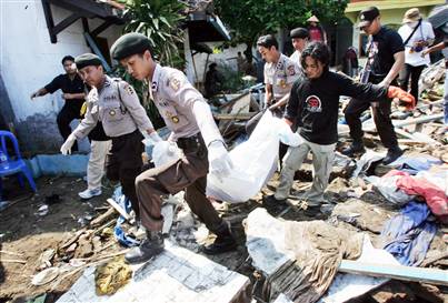 pangandaran - Rescuers carry the body of a tsunami victim in Pangandaran, Indonesia, on Wednesday. Jittery residents fled the resort town hardest-hit by Monday's tsunami amid unfounded rumors another killer wave was about to hit.