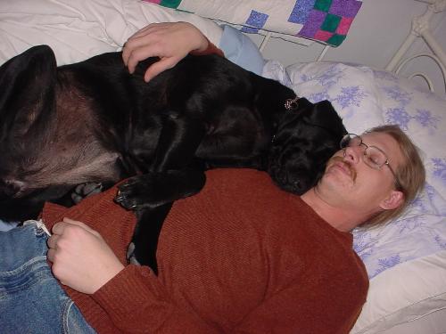 Charlie, my fiance, and my dog Ana - Charlie snuggling on the day bed in my office with Ana, my 6 year old black lab.