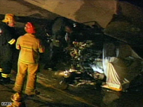 crashed - Firefighters examine the wreckage of a small helicopter that crashed on a California freeway.