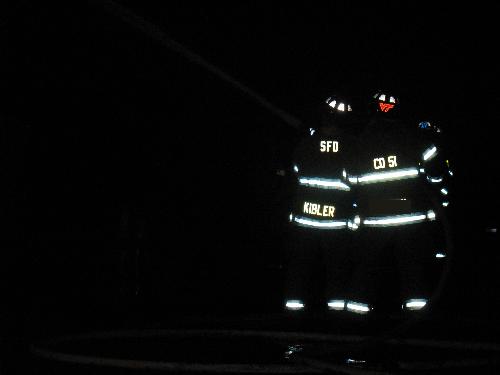 Firefighting - I am fighting a workshop fire with another member of our fire department. We are using an inch and three quarter hoseline to extinguish the blaze. I am the guy with the VT proudly glowing on my helmet. I am currently a student at Virginia Tech.