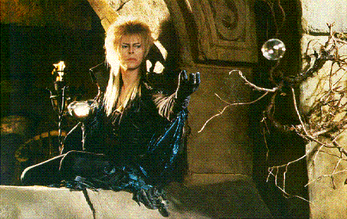 Jareth in a Window - Here's Jareth sitting on a windowsill in his castle in the Labyrinth. He is twirling crystals in his hand and sending them off. This is set just before the ballroom scene which takes place in one of these crystals/bubbles.
