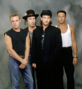 u2 - The four men, Bono, Edge, Adam and Larry stand as young men.