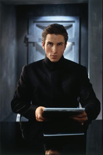 Christian Bale - Christian Bale sit with the light of the door way in the back drop film still from equlibrium