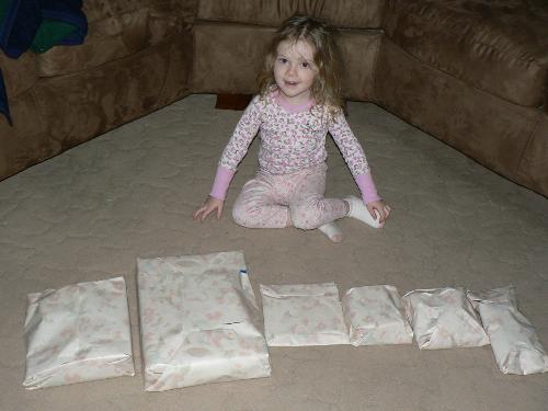 My daughter on Valentines day - This is a picture of my daughter on the morning of Valentines day before she opened her gifts from her father and I. She waited so patiently in the living room while I wrapped them in the next room and then she came in when they were done being wrapped and lined them all up in the living room and let me take her picture before she unwrapped them.