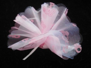 Christening Favours - Here is another sample of our baby girl christening favours, these are so pretty and if you have a christening coming up or a new born baby in the family then these favours will work well with any party or just as a gift. We also offer them in blue for the boys. On this favour you will see embroidered pink dummies and prams on the netting.