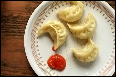 chicken momos - chicken momos served with red chilli sauce!