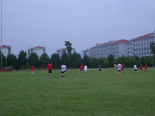 school life--playing football on campus - This is a picture of the teachers playing football on the playground. They usually play football once a week.