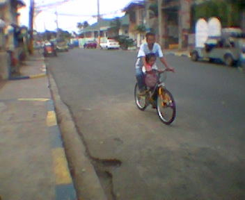 Off to school - morning doting dad transporting daughter to school via bicycle