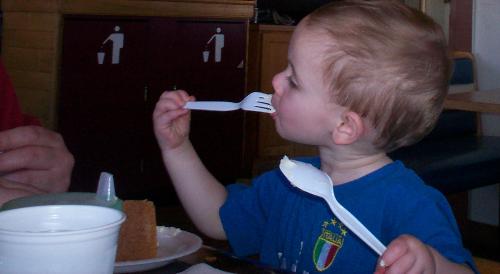 He loves cheesecake!  - My son eating cheesecake. He couldn't eat if fast enough so he used two utensils!!