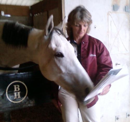 me and my horse - This is a picture of me and my horse, Bobbyn Bouie, looking at the race program and sizing up his competion in his last race. He finish fourth!!