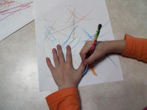Child's Art - A young child drawing on a piece of paper.