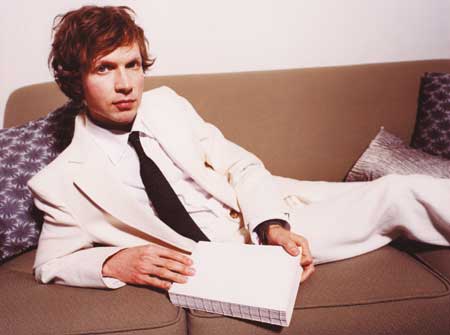 Beck - Full shot beck lounging on sofa wearing a white suite