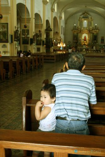 What am I doing here? - The Vigan City Church is one of the oldest ever built by the Spaniards in the Philippines. Here, a father prays while the son waits as if saying "what am I doing here"? 