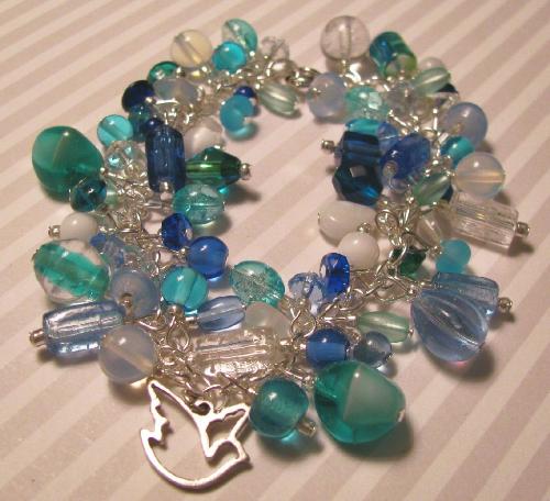 Peace Dove Bracelet - This is a new creation that will be put into my Etsy shop later today Aqua, blue, clear and white glass beads adorn this 8' bracelet. A few pieces of moonstone have been added to the mix to add some depth to the piece. At the center, floats a silver Dove charm. This bracelet can be sized up or down at your request... more photos of this piece can be found later this evening (3/18) at my shop on Etsy.com
