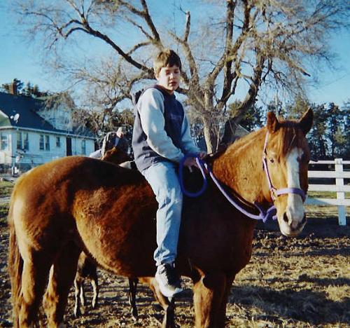 Tuff Glitter Bar in the south pen with Dawson - This is another picture of my stallion in the pasture with my son who was 14 at the time this picture was taken. This horse is a stallion. He is registered AQHA and as you can tell by the picture, he's a pretty mellow horse.