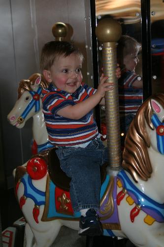 My son on the carousel for the first time - This picture brings joy to my eyes. My son was so happy to ride the horse, and I was running around it like crazy being sure he wouldn't fall.   The laughter that I witnessed made me so happy that I could have cried.