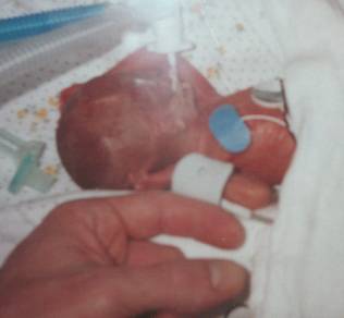 preemie size - my husbands finger next to our son