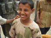 Iraqi boy - My son is stationed in Iraq and he has met some locals. We sent toys and teddy bears for the soldiers to hand out. Yes, these are his real teeth.