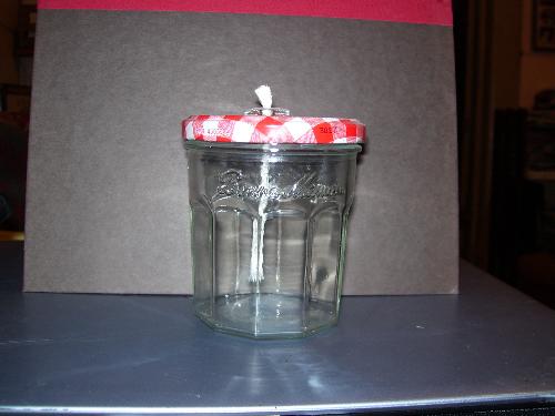 A jam jar oil lamp. - This particular brand has an attractive jar with a red plaid top. I buy wicks with glass tubes at Hobby Lobby, and drill a hole in the lid to insert them. I buy the same oil people put in their tiki torches.