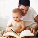 Here is to keeping memories precious - Picture of Caucasian father and baby looking through a book while father sits down on his side with baby in front of him