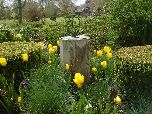 Michelham Priory - Sundial Garden - A sundial, set in a small garden planted with mainly yellow flowers. There's a very solid, wooden bench between the moat and the garden... an excellent place to watch time go by in thought of days gone by.