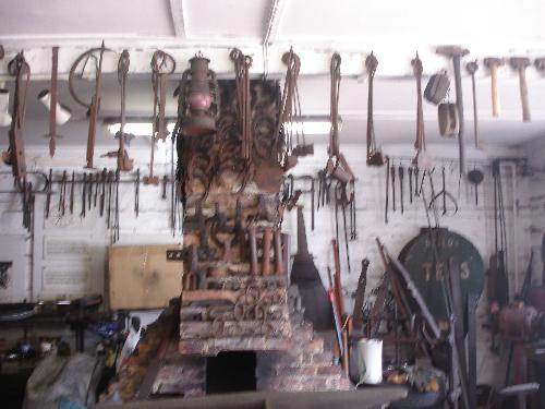 Michelham Priory - The Forge - The Forge at Michelham Priory with the Kiln being the centre point. Note all the finished work hanging around the kiln, and the anvils on the right/hand side.