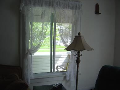 Curtains with cheap tiebacks - This costs about a dime a window, compared to a minimum of $15 for a set of elaborate tiebacks!