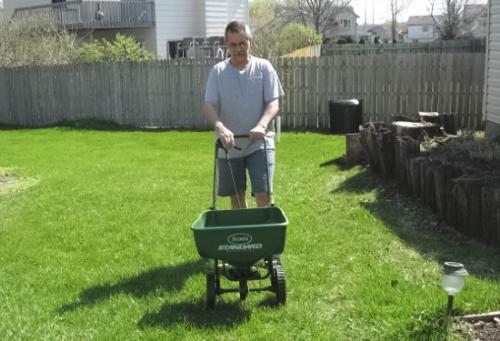 A Busy Grandpa Bob - Preparing the lawn for hopefully, a very nice  green and healthy appearance this summer.