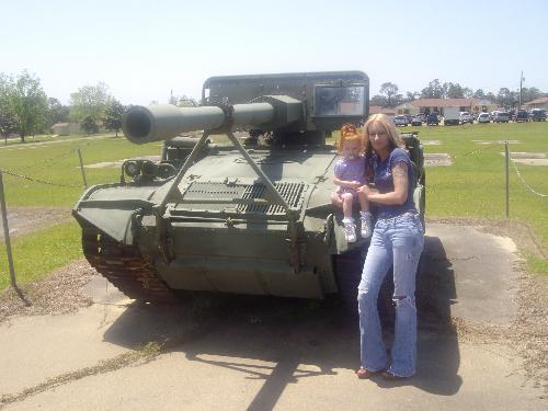 me and my daughter - mt daughter and i sitting on a smaller tank. well she is sitting, i'm standing next to her