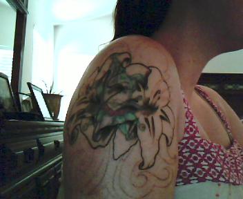The outline of the cover up on my arm. - This will be two lily's with some type of a design on the top and bottom of them, when they are done. The bigger lily will be purple but I am having trouble deciding what colors to do the other lily and then the colors on top and bottom...