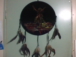 My DreamCatcher - This is my dream catcher, and though it may be a little hard to make out detail cause its so dark, it has an Indian medicine man in the center.