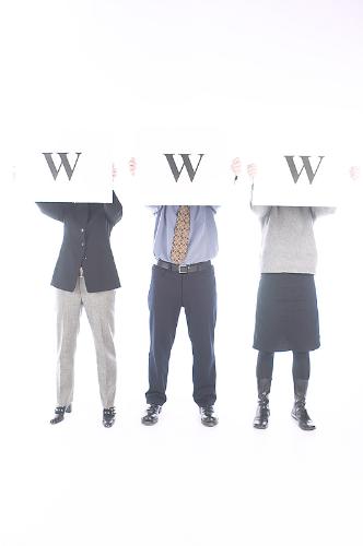 Three people and the internet - This is a picture of three people. They are holding up signs with a W on it. They are wearing clothes. They are wearing shoes. There are two men and one woman. The internet is also known as www That stands for world wide web