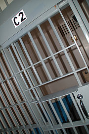 Prison bars - To hold a prisoner in a cell apart from others.