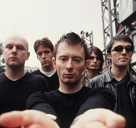 Radiohead - Thom in center of radiohead band full shot with his hands out and open palm side up