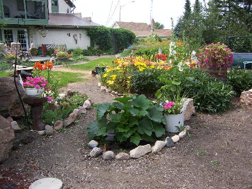 One section of our garden with lilies in bloom - We have a large backyard and have landscaped the whole thing ourselves. This photo is just one section and shows our lilies in full bloom. This is the view from the hammock area.