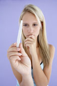 teenage pregnancy - a teenager holding a pregnancy test kit