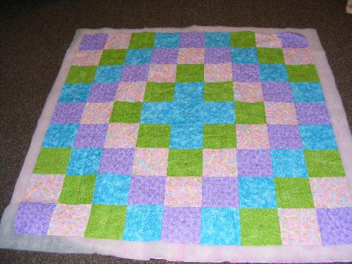 Baby Quilt - This baby quilt is done with simple 6 1/2-inch squares in a pattern that repeats itself "backwards". The colors aren&#039;t the typical pastels, but instead, bold colors that draw the eye. 