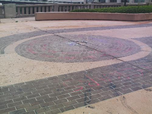 Center of the Universe close-up - The Center of the Universe has been vandalized and tagged. It looks like Brad and Michelle had some red spray paint when they left their 'autographs'. Also, some of the bricks have been removed.