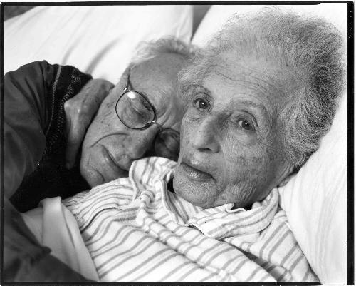 photo of elderly lying down - This photo shows an elderly couple lying down on a bed.