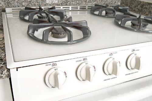 Stove - This is a photo of a stove. It is an appliance that you cook on. It has four burners. It is a gas stove. It is very modern because it tells you which knob is for which burner. Mine doesn't have that. I do not like using matches to light it.