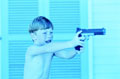 a little boy aiming a gun - a boy playing with a toy gun and aims it.