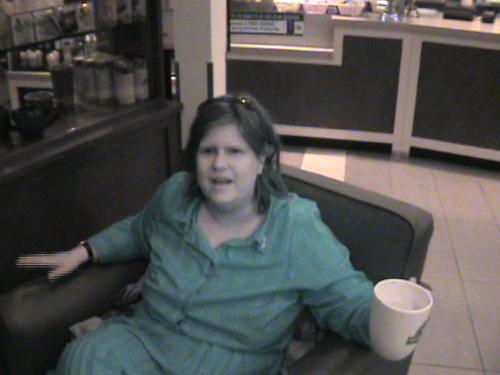 Just Me And My Coffee - I was actually wearing a black dress, but I forgot to turn off my night-shot, so I look like I'm wearing green. LOL   Anyway, this was taken a few minutes after I got home from Arizona, last month. I dropped my luggage off at home, and headed straight for he Second Cup.