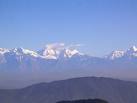 The Himalayas - Snow covered mountains in the background of a jungle less mountain range.