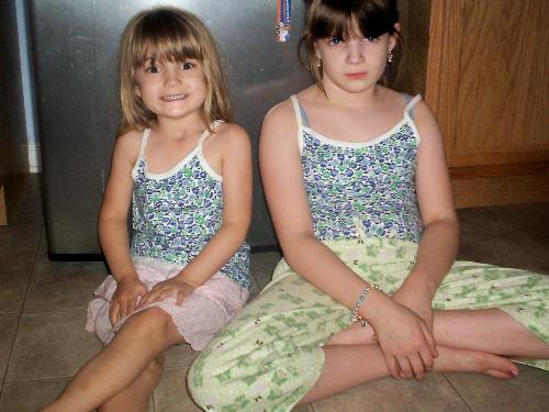 My girls in their matching tops - My oldest isn't happy that her sister has a blouse that is like her's.