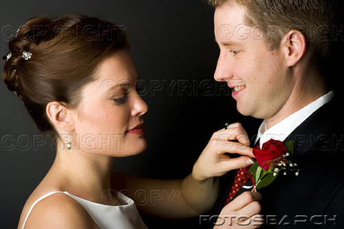 get married - Bride adjusting flower on suit.