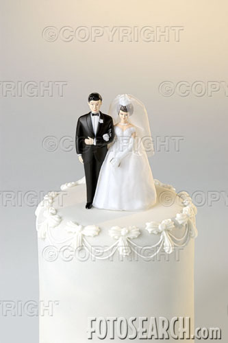get married - High angle looking down on the top of a wedding cake with a miniature bride and groom cake topper.